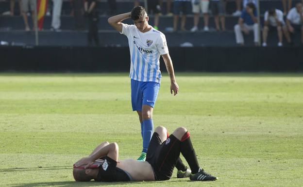 El juvenil José Carlos, uno de los habituales del filial, pasa junto a un jugador del Adarve al retirarse el sábado.