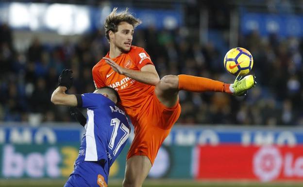Ignasi Miquel, en su debut con el Málaga, intenta controlar el balón en pugna con Pedraza en el choque de Vitoria antes de las vacaciones. /Efe