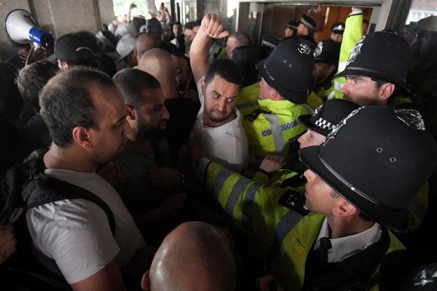 Varios vecinos intentan acceder a las oficinas municipales de Kensington. :: Toby Melville / reuters/