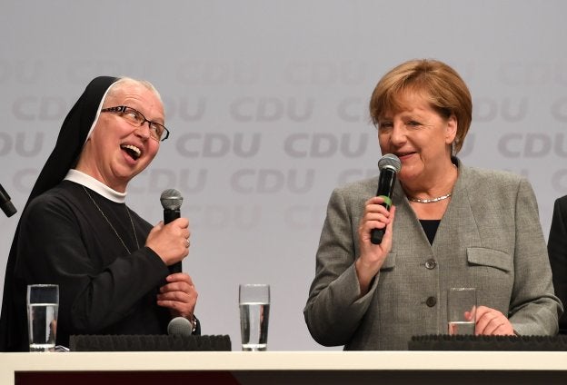 Angela Merkel, en animada charla con una monja durante un acto electoral de su partido, la CDU, en Dortmund. :: PATRIK STOLLARZ / afp