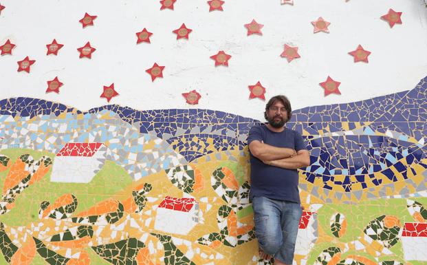 Patxi Velasco, junto al mural con los nombres de los alumnos del barrio que terminan Secundaria