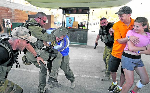 Simulación: Los instructores, antiguos miembros de unidades especiales del Ejército hebreo, repelen un simulacro de agresión con cuchillo junto a dos de sus clientes.