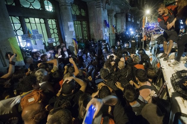 Mossos d'Esquadra intentan contener a los manifestantes ante la Consejería de Economía en la madrugada del miércoles. :: Quique García / efe/