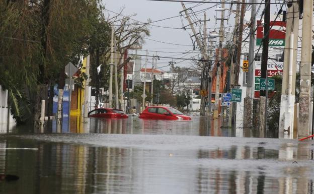 Dos coches flotan en una calle totalmente inundada en San Juan (Puerto Rico). /Efe