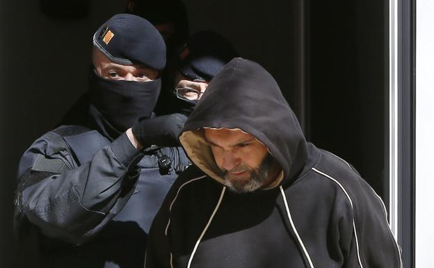 Agentes de los Mossos custodian a uno de los nueve yihadistas detenidos en 2015./Susana Sáez (Efe)