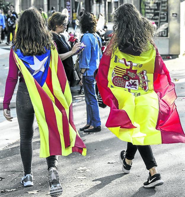 División identitaria. Las dos banderas, la constitucional y la indepentista, rivalizan en calles y balcones. :: andreu dalmau-Efe/