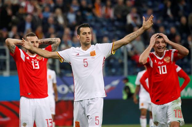 Sergio Busquets gesticula entre Fyodor Kudryasho y Alan Dzagoev durante el amistoso disputado ayer en San Petersburgo entre Rusia y España. :: Maxim Shemetov. reuters/