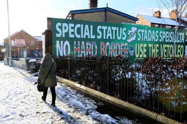 Una joven camina junto a un cartel que pide en Belfast un estatus especial para Ulster. :: Paul FAITH / afp/