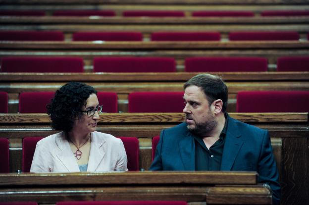 Marta Rovira y Oriol Junqueras conversan en los escaños del Parlament de Cataluña. :: inés baucels/