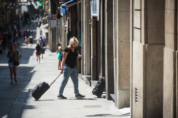 Una turista con su maleta antes de acceder a un piso turístico en el centro de Barcelona. :: I. baucells/