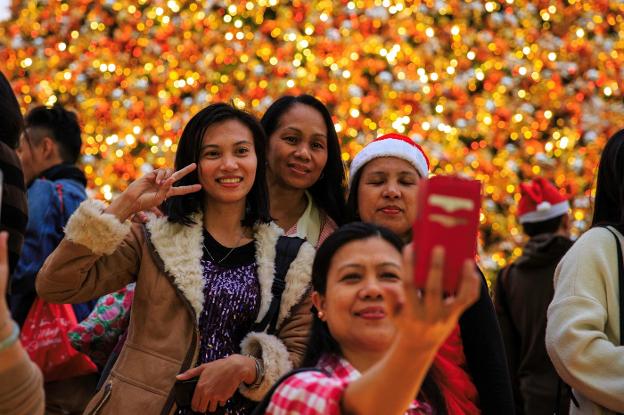 Mujeres filipinas se hacen un selfi en la excolonia británica. :: afp/