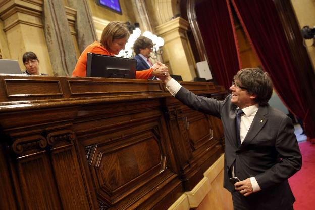 Puigdemont saluda a la presidenta del Parlament, Carme Forcadell, tras uno de los tormentosos plenos de septiembre pasado. :: toni albir / efe/