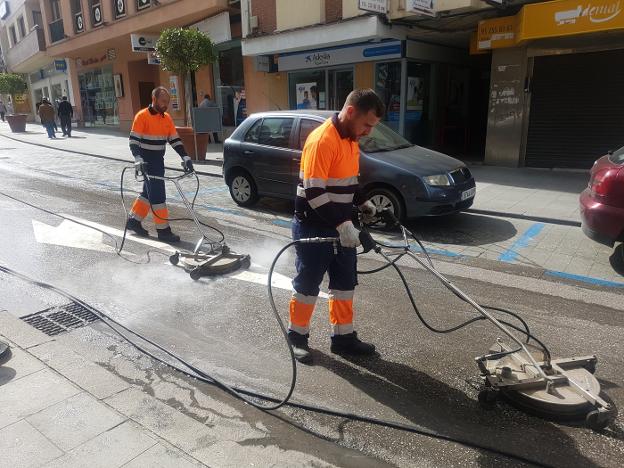 Operarios de la limpieza retiran la cera de las calles. /A. Peláez