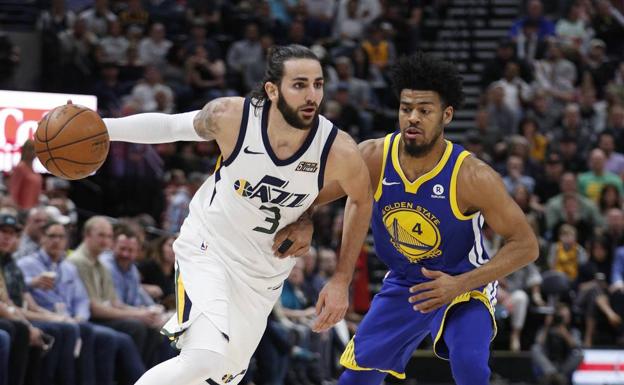 Ricky Rubio bota el balón ante Quinn Cook, de los Warrios./Efe