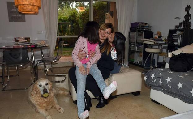 Chloe, a la izquierda, besa a su madre junto a su hermana Kaia y el perro de la familia, en el salón de su casa. /Josele-Lanza -