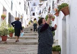 Una vecina pasea un perro por una calle típica del casco histórico de Frigiliana. :: E. Cabezas/