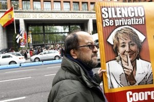 Un manifestante porta un cartel contra Esperanza Aguirre. ::
CHEMA MOYA. EFE/