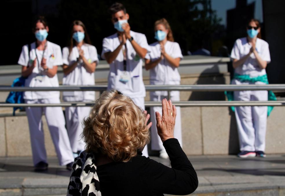 Una mujer ovaciona, ayer, a un grupo de enfermeros que se concentraron ante el hospital de La Paz, en Madrid. j. medina / reuters/