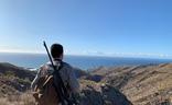 Un cazador, con su escopeta y su morral al hombro, otea el horizonte en un coto./federación andaluza de caza