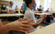 Escolares con mascarillas se lavan las manos con gel hidroalcohólico./reuters