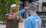 Un sanitario toma la temperatura a un hombre./Reuters