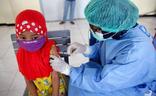 Un sanitario vacuna a una niña en Indonesia./EFE