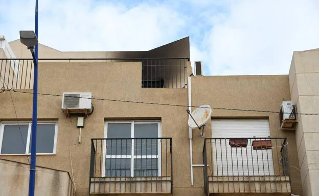 Vista de la vivienda en la pedanía de El Alquian de Almería tras el incendio registrado esta mañana que mató a una madre y sus dos hijos menores de edad
